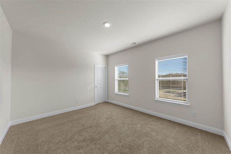 Empty room with baseboards and light colored carpet