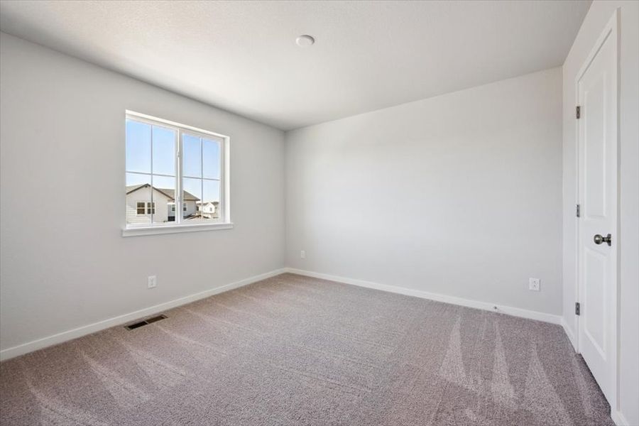 A room with a window and a carpet.