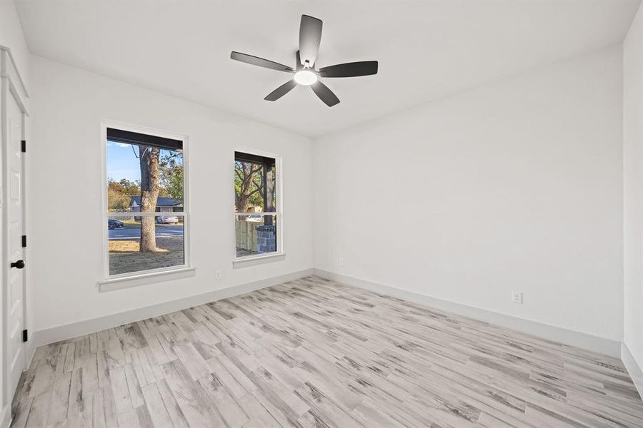 Spare room with light wood-style flooring and a ceiling fan Spare room with light wood-style flooring and a ceiling fan