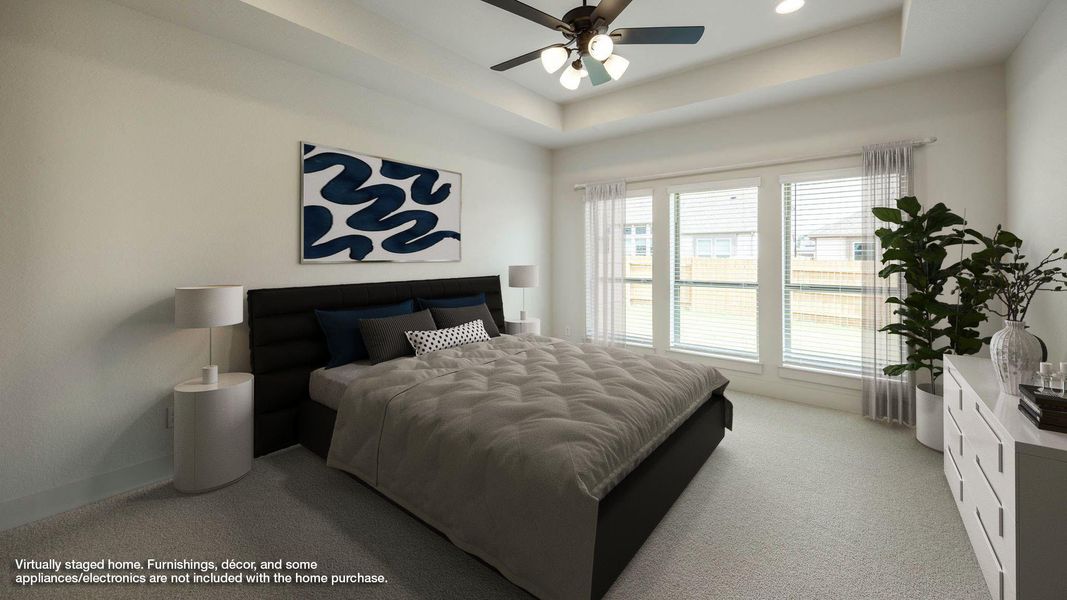 Bedroom with carpet, a tray ceiling, and ceiling fan
