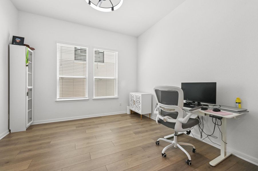 Warm wood flooring and clean walls shape a versatile workspace.