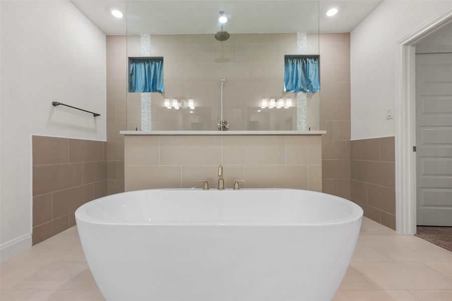 Bathroom featuring tile walls, light tile patterned flooring, a freestanding bath, a walk in shower, and recessed lighting Bathroom featuring tile walls, light tile patterned flooring, a freestanding bath, a walk in shower, and recessed lighting