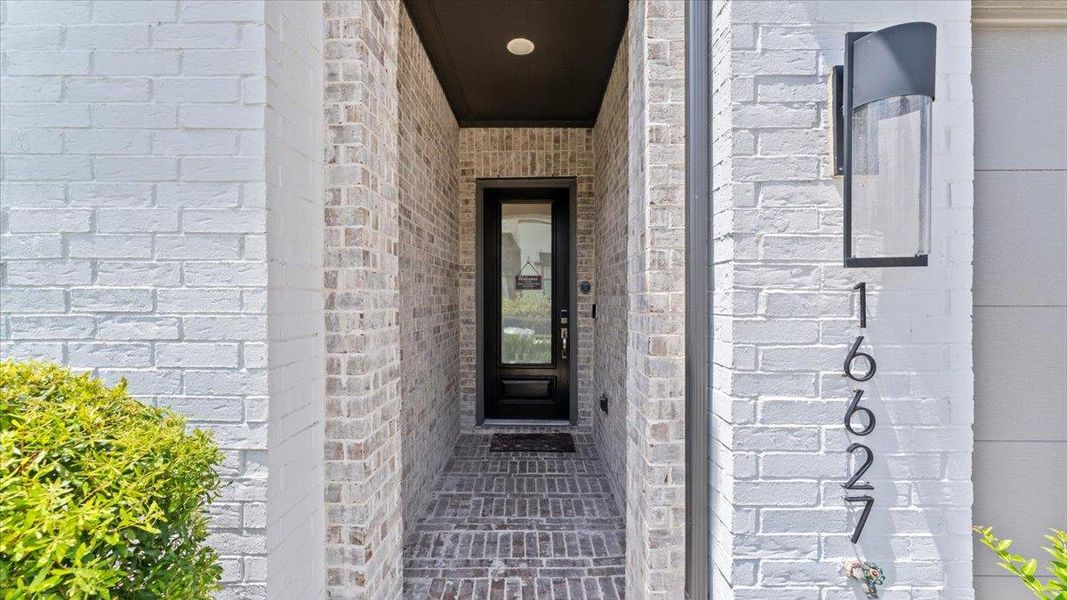Doorway to property featuring brick siding Doorway to property featuring brick siding