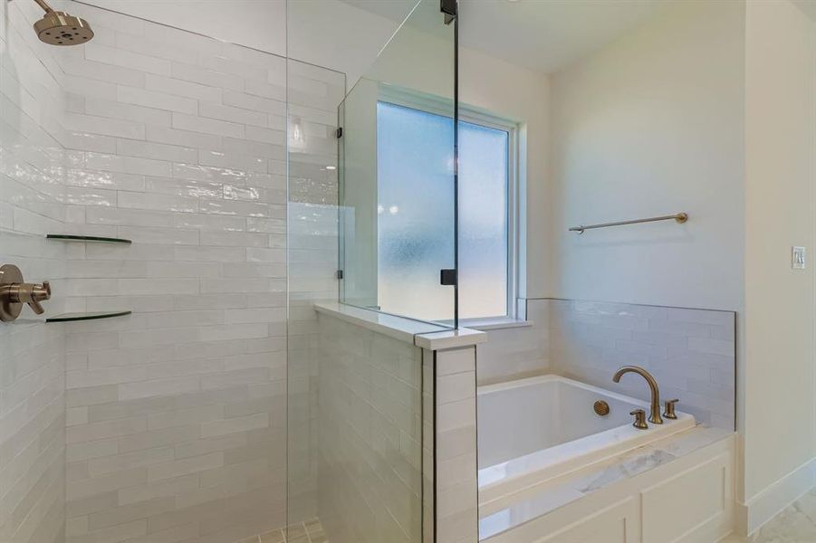 Bathroom featuring a walk in shower and a bath