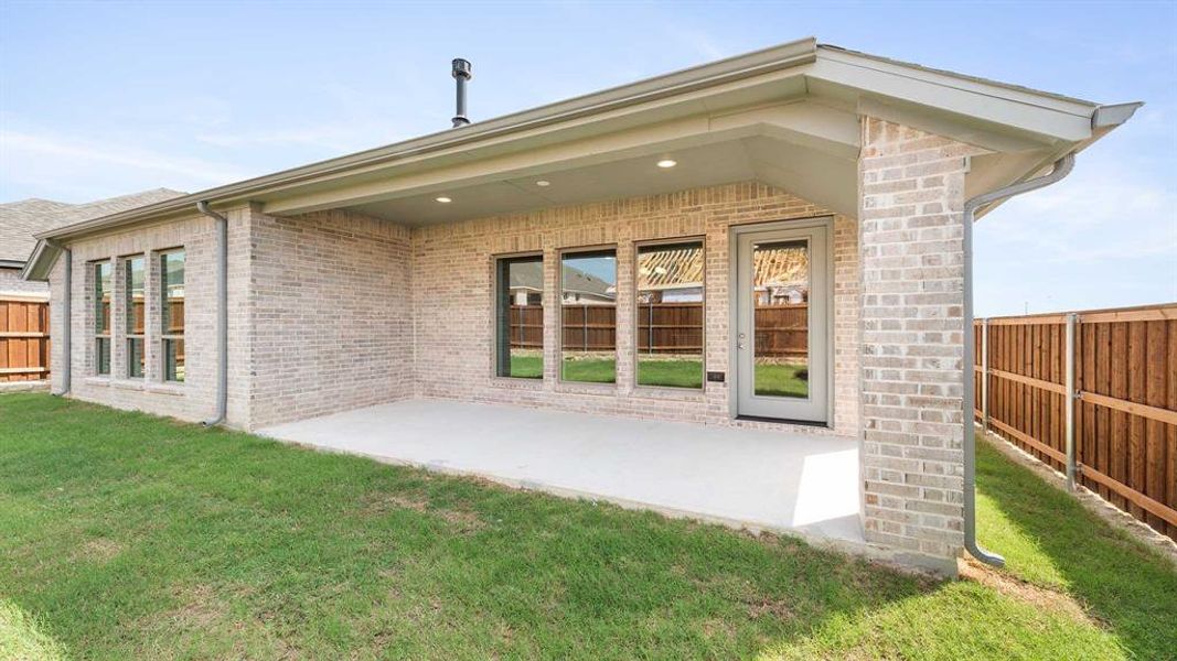 Rear view of property with a yard and a patio