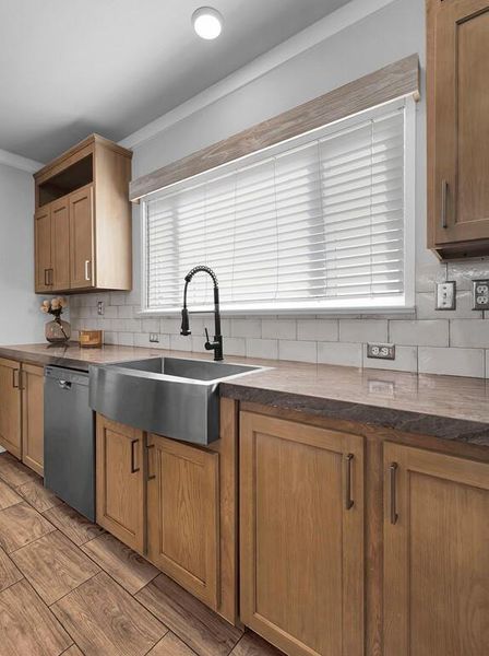 Kitchen featuring tasteful backsplash, dishwashing machine, brown cabinets, open shelves, and ornamental molding Kitchen featuring tasteful backsplash, dishwashing machine, brown cabinets, open shelves, and ornamental molding