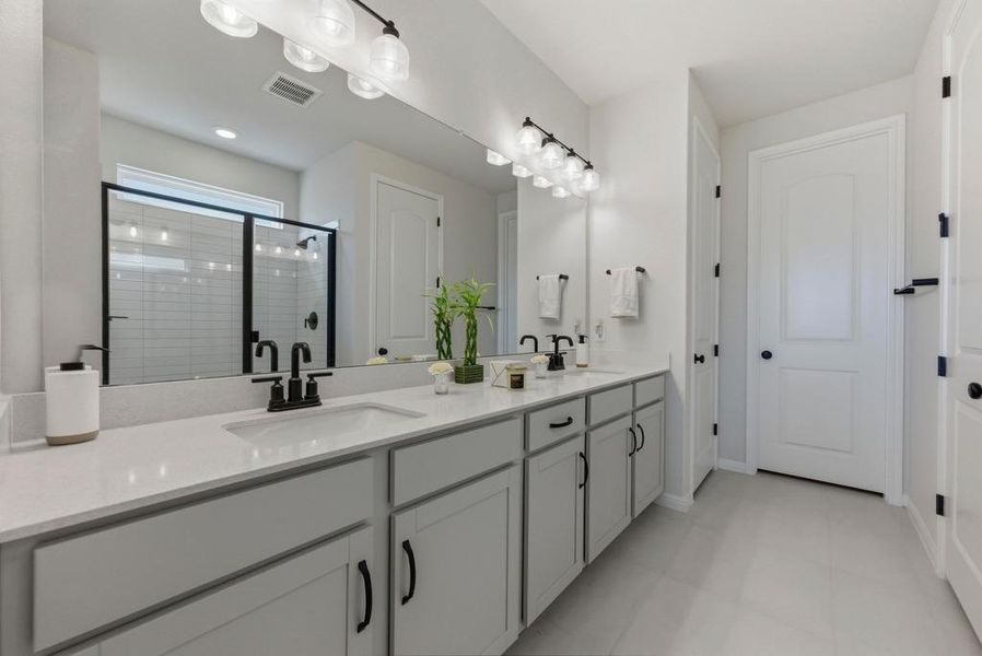 Full bath featuring double vanity and a shower stall