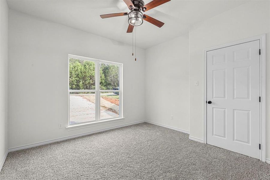 Carpeted spare room featuring ceiling fan