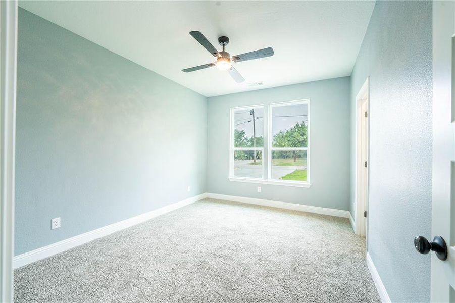 Carpeted spare room with ceiling fan