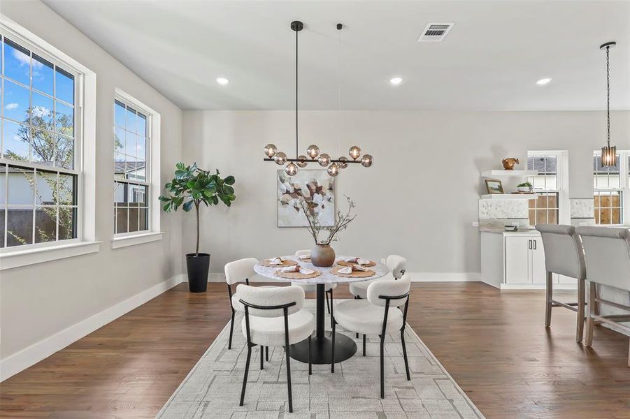 Dining room with a chandelier, dark wood-type flooring, and recessed lighting Dining room with a chandelier, dark wood-type flooring, and recessed lighting
