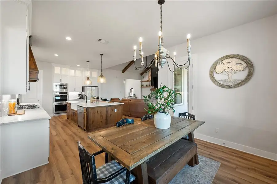 Dining area featuring light wood-style flooring, a chandelier, recessed lighting, and beamed ceiling
