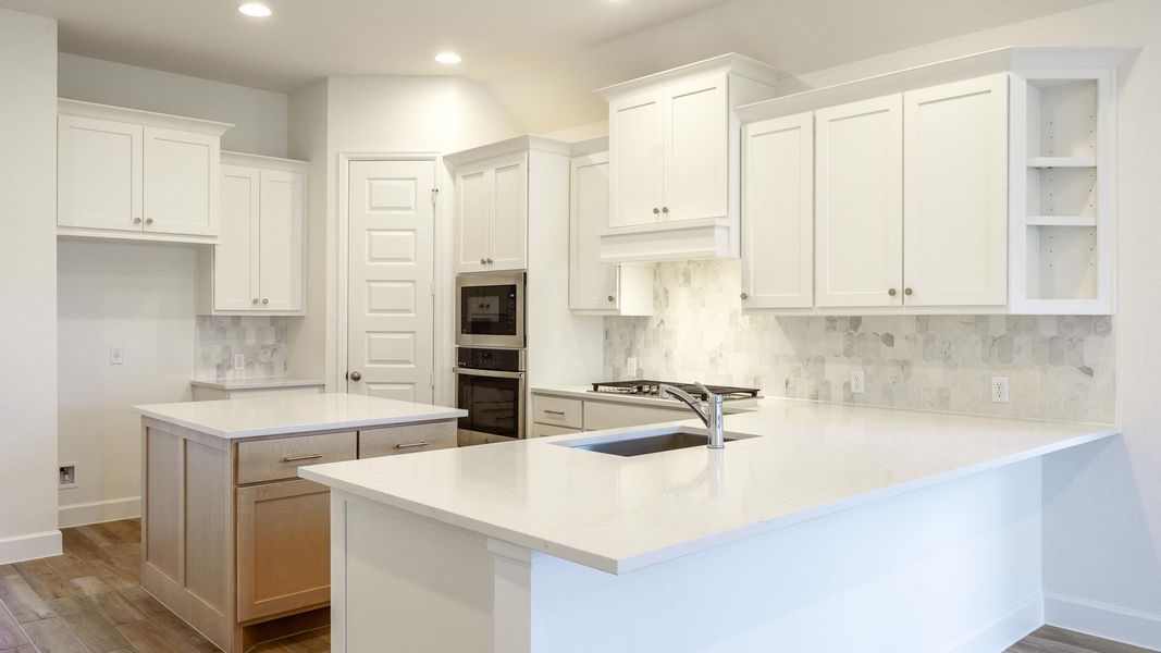 Kitchen featuring white cabinets, decorative backsplash, light stone counters, dark wood-type flooring, and stainless steel oven