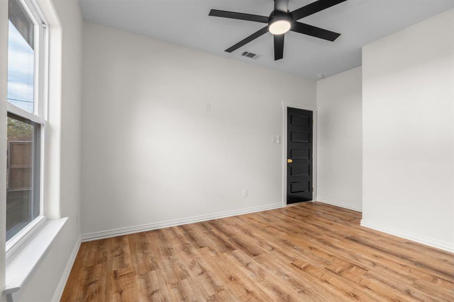 Empty room featuring light wood-style flooring and ceiling fan Empty room featuring light wood-style flooring and ceiling fan