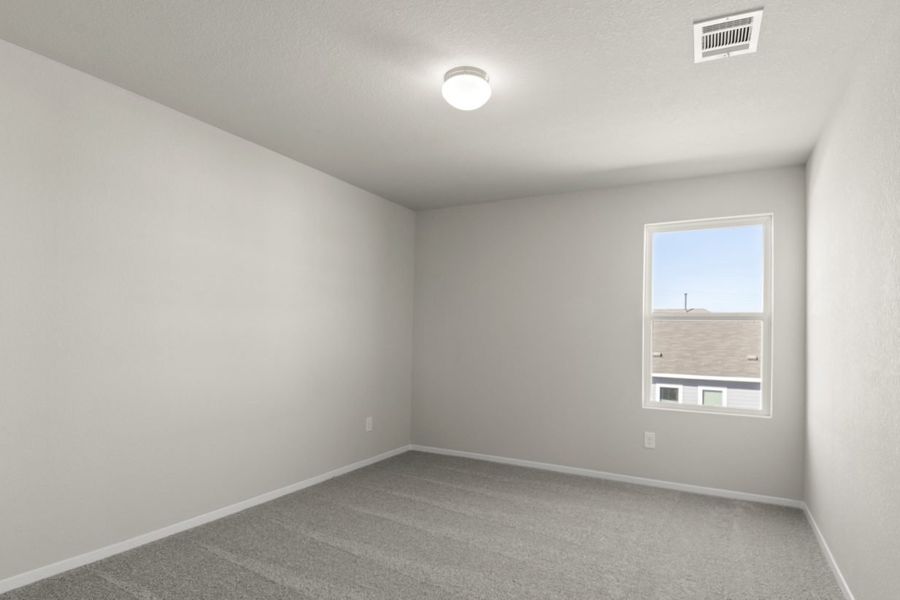 Image of a bedroom with cream walls, tan carpeting, a window and white trim