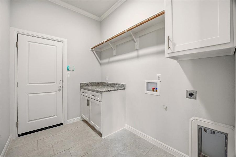 Laundry room featuring crown molding, cabinet space, hookup for a gas dryer, washer hookup, and electric dryer hookup Laundry room featuring crown molding, cabinet space, hookup for a gas dryer, washer hookup, and electric dryer hookup