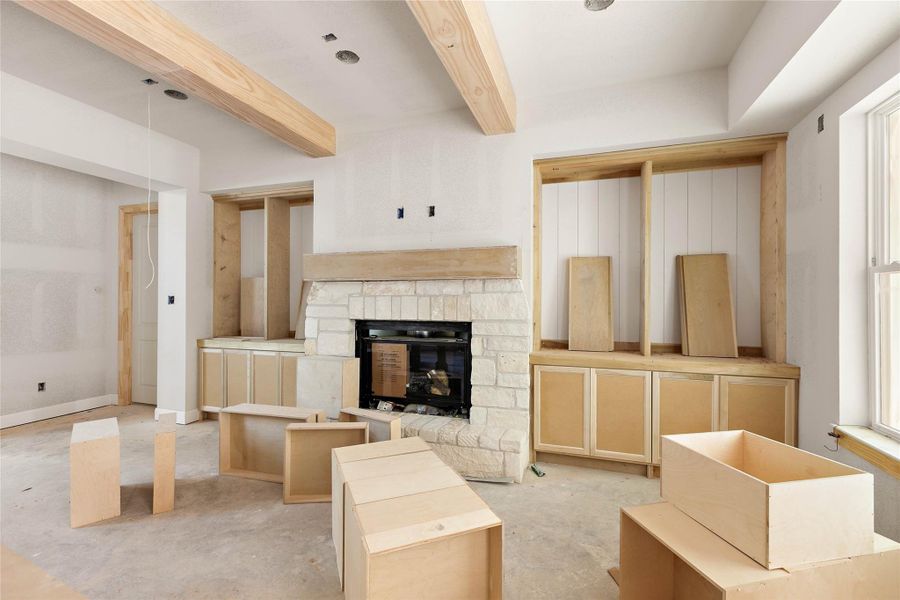 Architectural details in the living room include wood beams, a stone framed fireplace with floating mantle and thoughtful built-ins. Architectural details in the living room include wood beams, a stone framed fireplace with floating mantle and thoughtful built-ins.