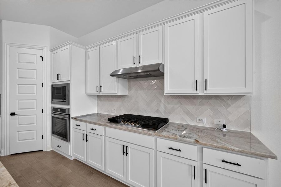 Premium stone countertops and modern cabinetry highlight this sleek kitchen workspace. Premium stone countertops and modern cabinetry highlight this sleek kitchen workspace.