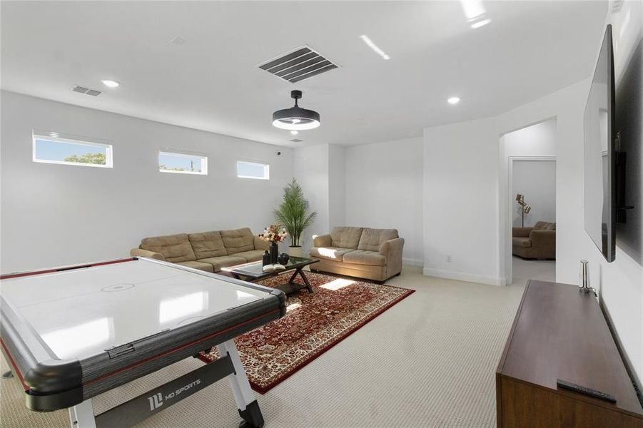 Spacious room featuring white walls, carpet flooring, recessed lighting, and a modern ceiling fan