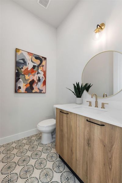 Stylish powder bath featuring custom tile flooring, modern wood-tone vanity cabinetry, designer lighting, and upscale contemporary finishes that elevate everyday living.