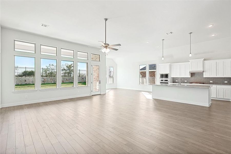 Unfurnished living room with dark wood-type flooring, ceiling fan, and sink