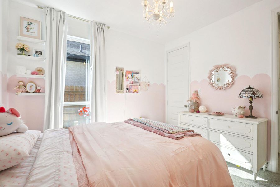 Bedroom featuring suspended lighting and carpet