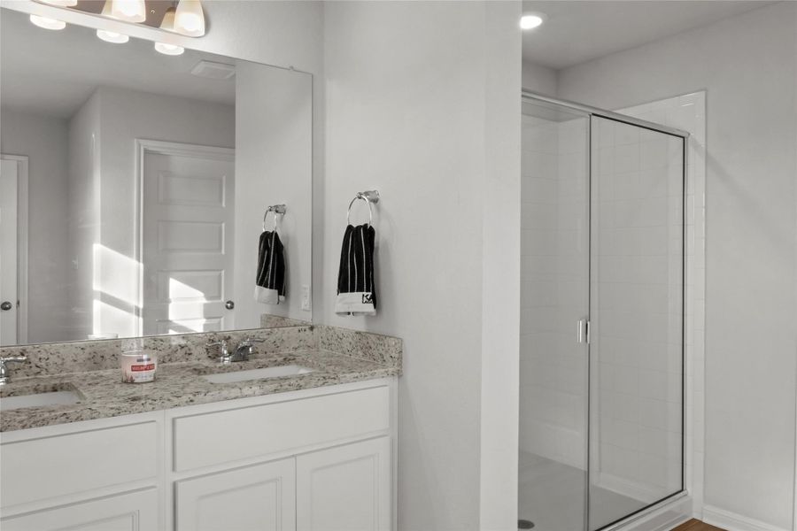 Bathroom with double vanity and a stall shower
