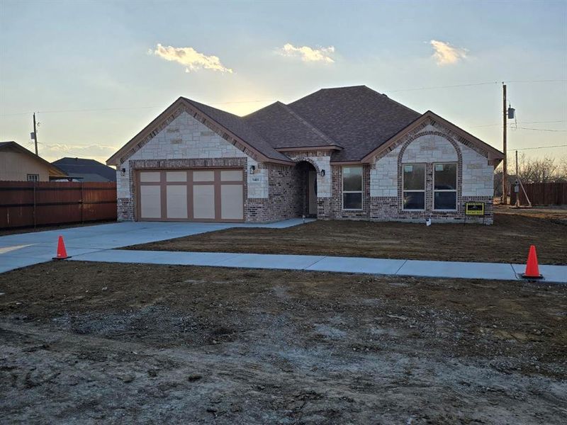 View of front facade with driveway, an attached garage, stone siding, and roof with shingles View of front facade with driveway, an attached garage, stone siding, and roof with shingles
