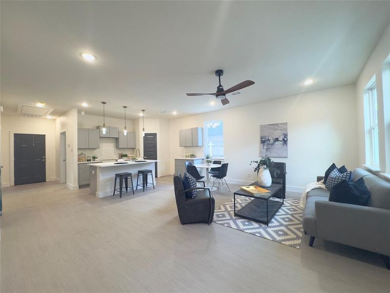 Living room featuring a healthy amount of sunlight, ceiling fan, sink, and light hardwood / wood-style floors