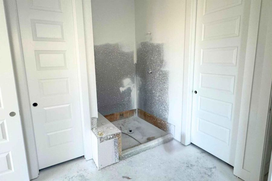 Bathroom with a shower stall and concrete floors