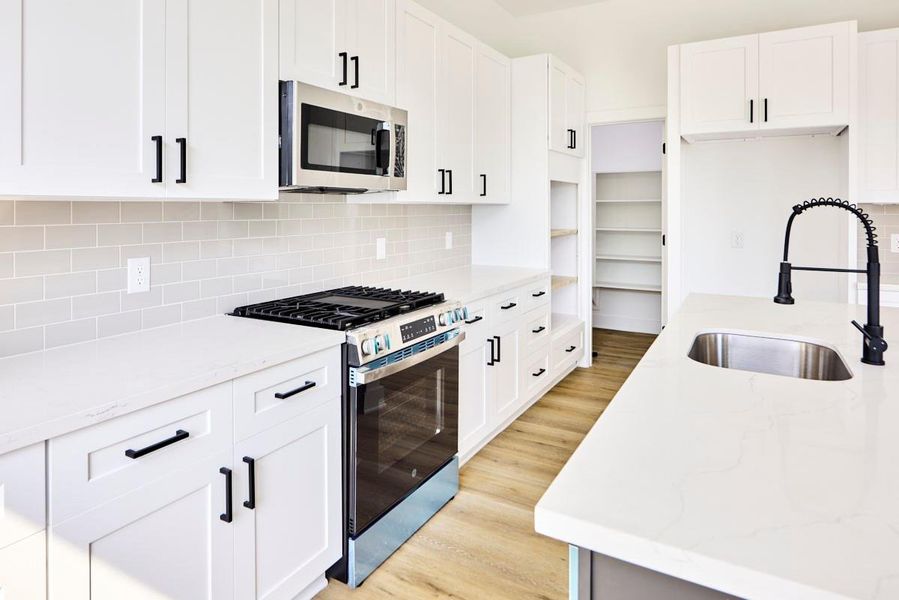 Elegant quartz countertops and high-end stainless steel appliances highlight this modern kitchen. The perfect blend of form and function, this kitchen is ideal for both everyday cooking and impressive dinner parties. Elegant quartz countertops and high-end stainless steel appliances highlight this modern kitchen. The perfect blend of form and function, this kitchen is ideal for both everyday cooking and impressive dinner parties.