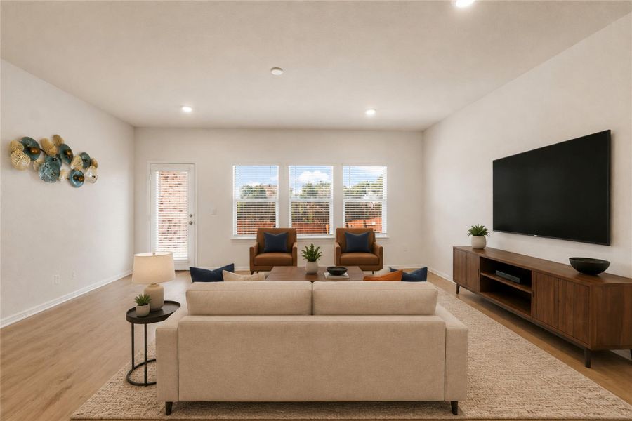 Living area showcasing recessed lighting, rich hardwood flooring and outdoor access.