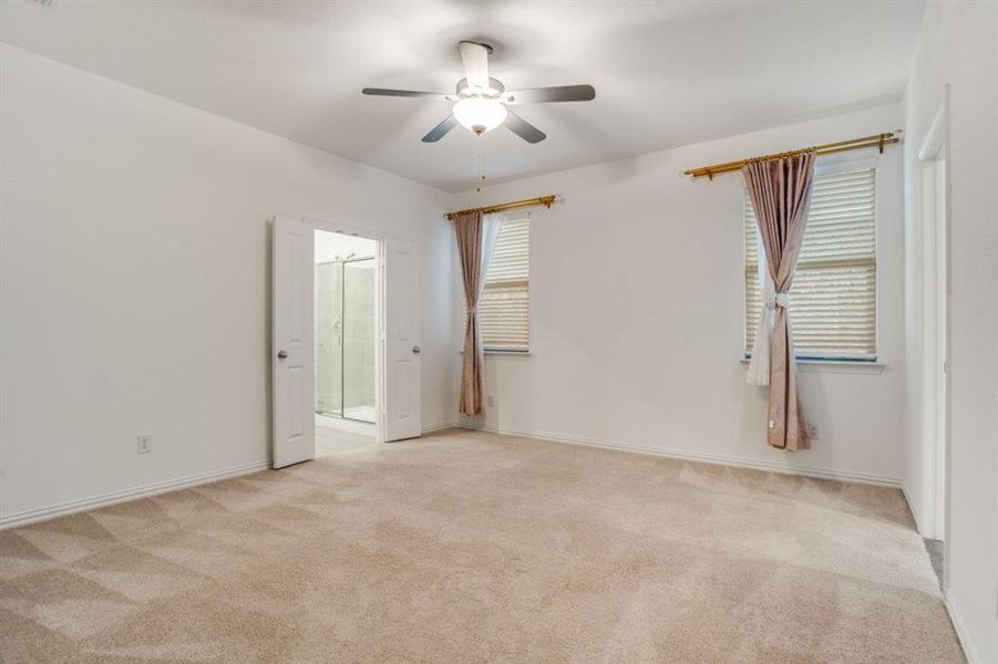 Unfurnished room with light colored carpet and ceiling fan