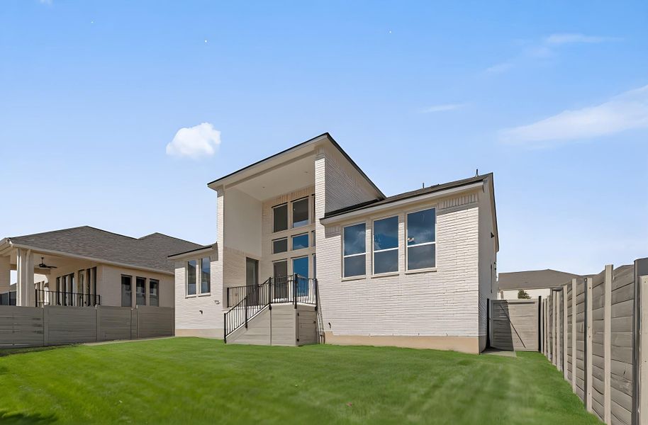 Back of house with a fenced backyard and a balcony Back of house with a fenced backyard and a balcony