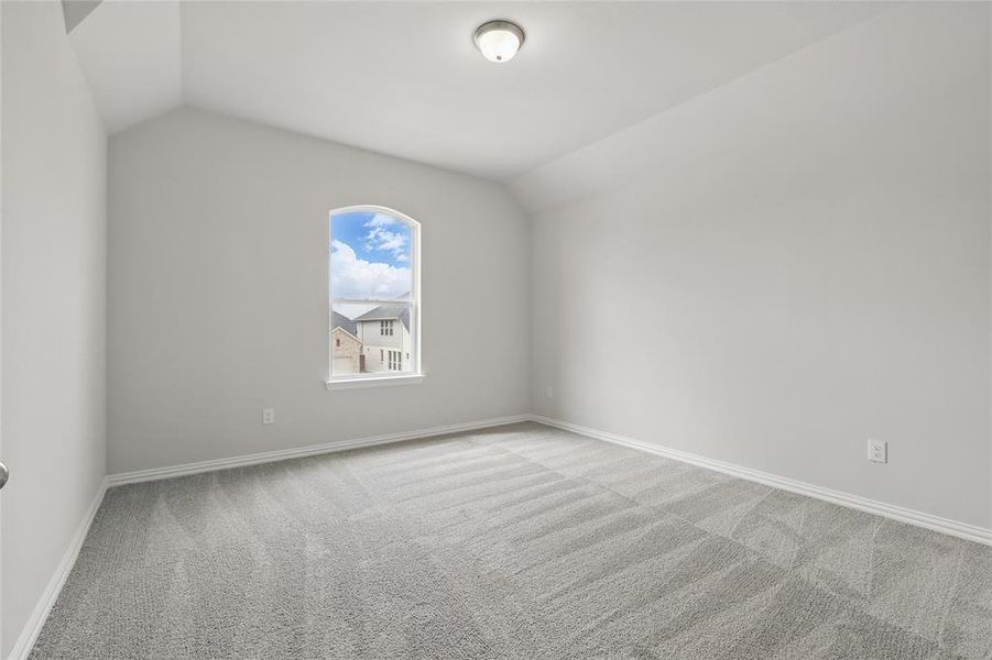 Unfurnished room with light carpet and vaulted ceiling