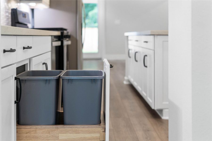 Smart storage solutions include a convenient pull-out trash and recycling center built directly into the island. Smart storage solutions include a convenient pull-out trash and recycling center built directly into the island.