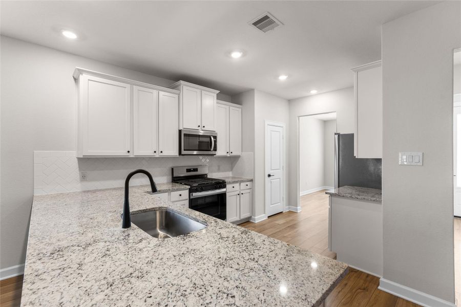 Modern kitchen featuring granite countertops, stainless steel appliances, a large breakfast bar, and abundant cabinet space. Open to the living area, making it perfect for entertaining and everyday living Modern kitchen featuring granite countertops, stainless steel appliances, a large breakfast bar, and abundant cabinet space. Open to the living area, making it perfect for entertaining and everyday living