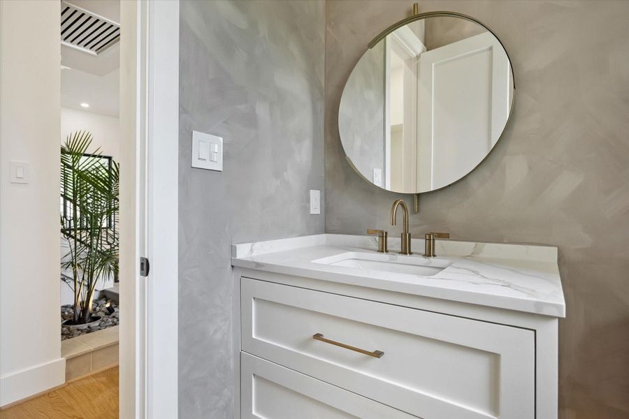 Stylish powder bath on the first floor features a floating vanity, quartz counter, and designer fixtures and wall paint finish. Stylish powder bath on the first floor features a floating vanity, quartz counter, and designer fixtures and wall paint finish.