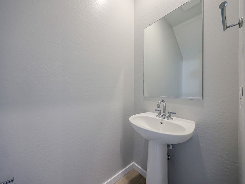A bathroom with a mirror and sink. A bathroom with a mirror and sink.