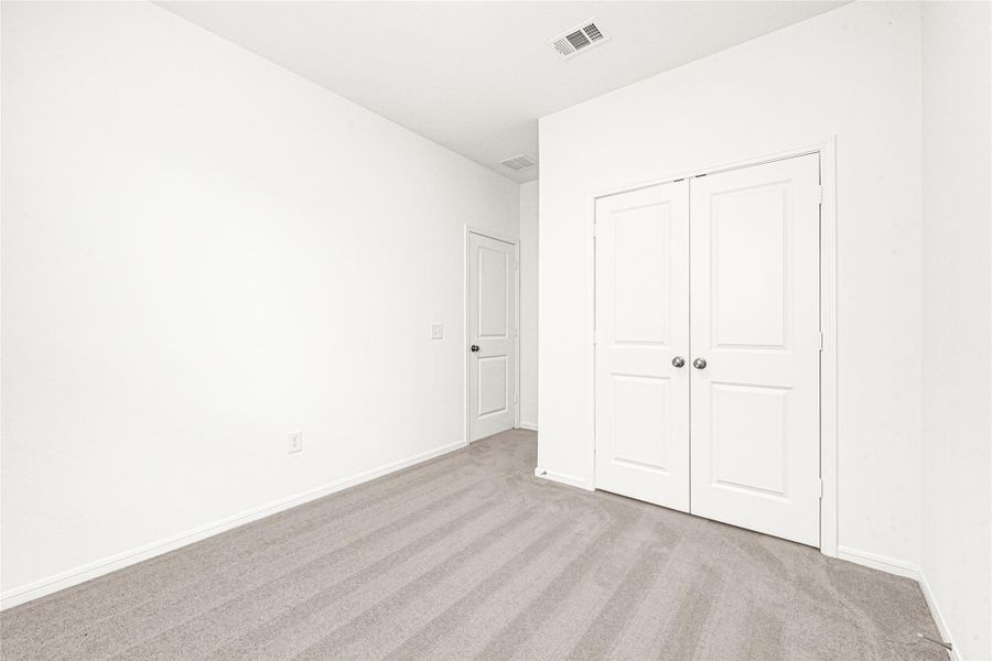 Generously sized multi-purpose flex room or den area with plush carpeting, perfect for a home office or playroom.