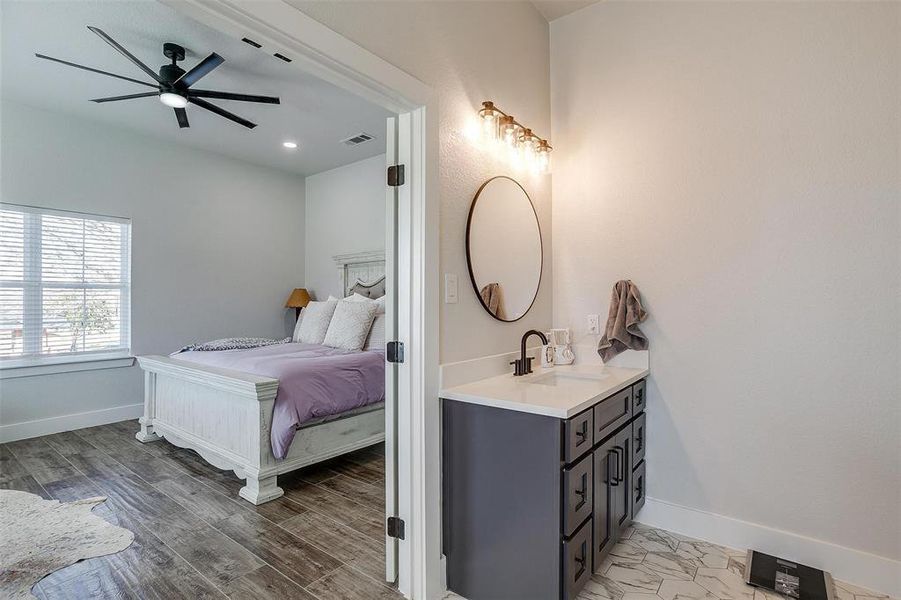 Bedroom featuring sink, hardwood / wood-style floors, and ceiling fan