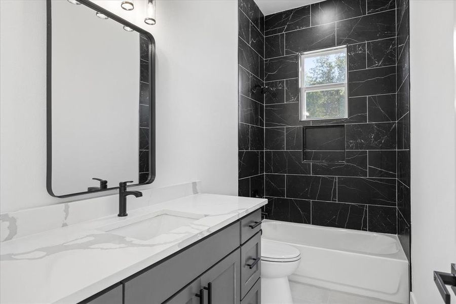 Kids Full Bathroom featuring a single vanity with a white countertop and integrated sink, matte black faucet, and a large framed mirror