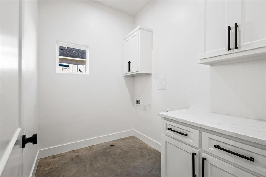 Laundry room featuring washer and dryer hookup, cabinets with quartz counter space