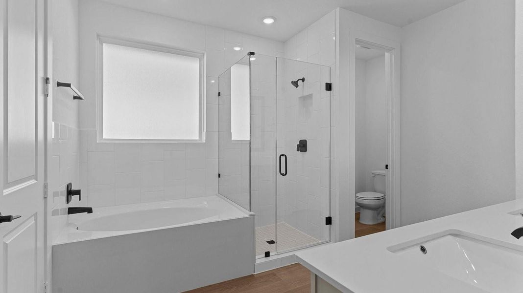 Primary bathroom with a glass-enclosed standing shower and separate soaking tub.