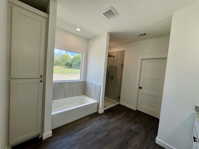 Full bathroom with a garden tub, a stall shower, dark wood-type flooring, vanity, and recessed lighting Full bathroom with a garden tub, a stall shower, dark wood-type flooring, vanity, and recessed lighting