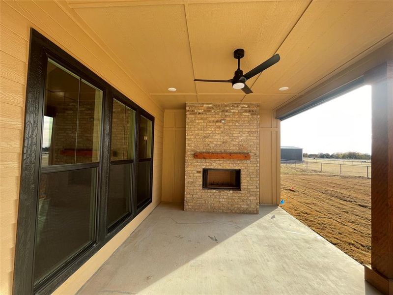 View of patio / terrace with ceiling fan and an outdoor brick wood burning fireplace