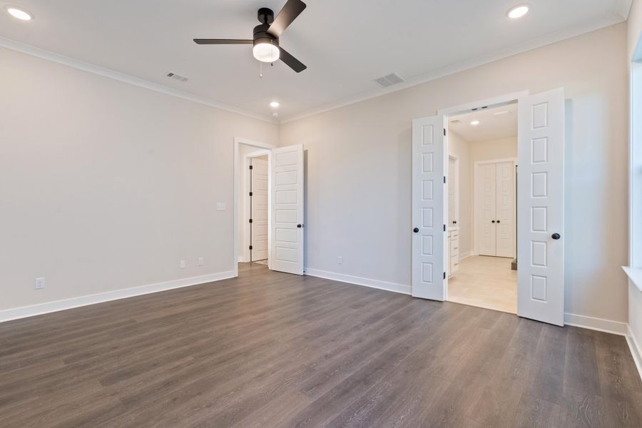 Unfurnished bedroom with recessed lighting, dark wood-type flooring, crown molding, and a ceiling fan Unfurnished bedroom with recessed lighting, dark wood-type flooring, crown molding, and a ceiling fan