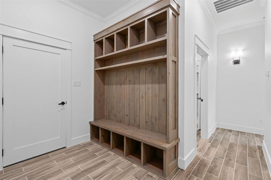 Mudroom with crown molding and wood tiled floors Mudroom with crown molding and wood tiled floors