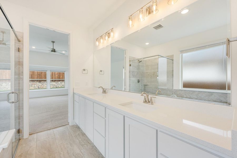 Master bathroom with double vanity, white cabinets, quartz countertops, and glass walk-in shower Master bathroom with double vanity, white cabinets, quartz countertops, and glass walk-in shower