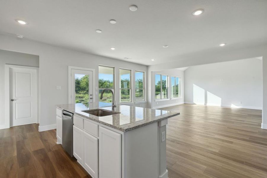 Kitchen with a healthy amount of sunlight, sink, stainless steel dishwasher, and a center island with sink