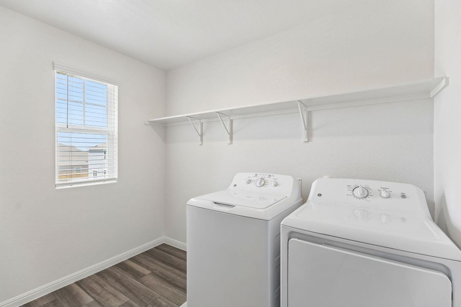 Laundry room with dark wood finished floors and washer and clothes dryer